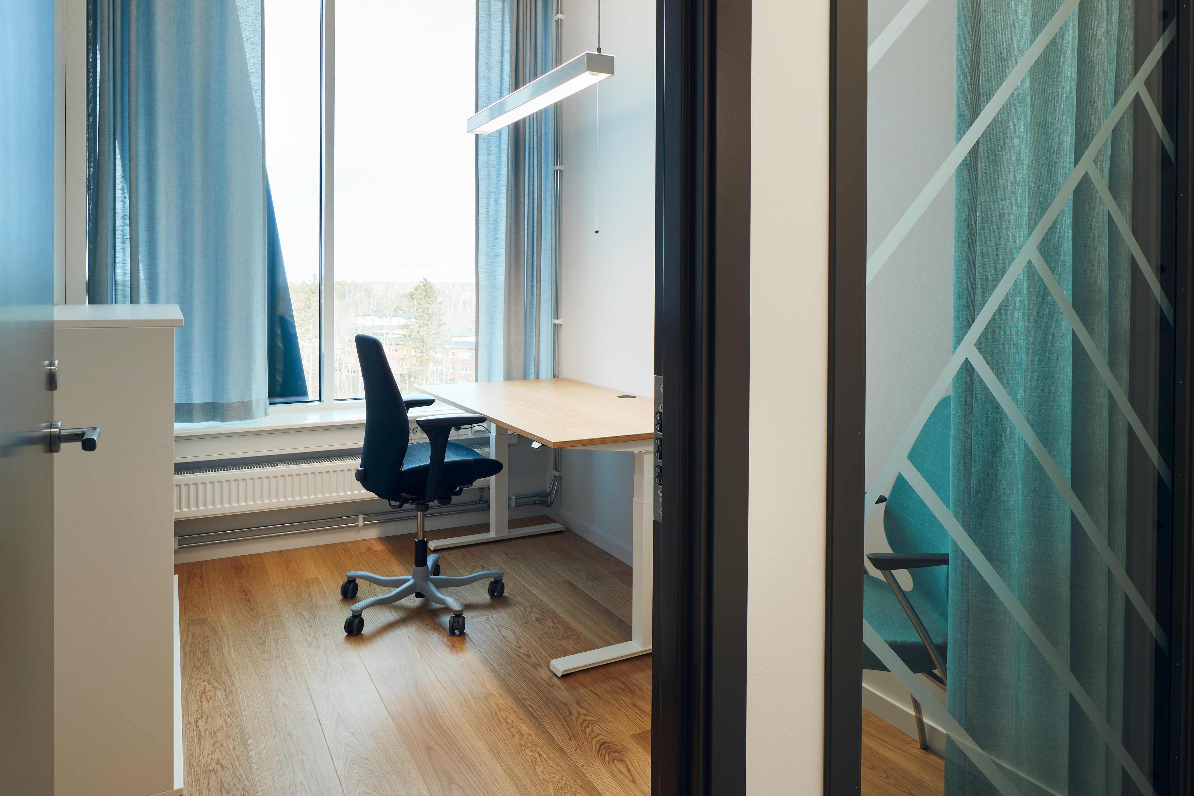 Kontorsrum för en person med skrivbord, kontorsstol, besöksstol och förvarningsmöbel.