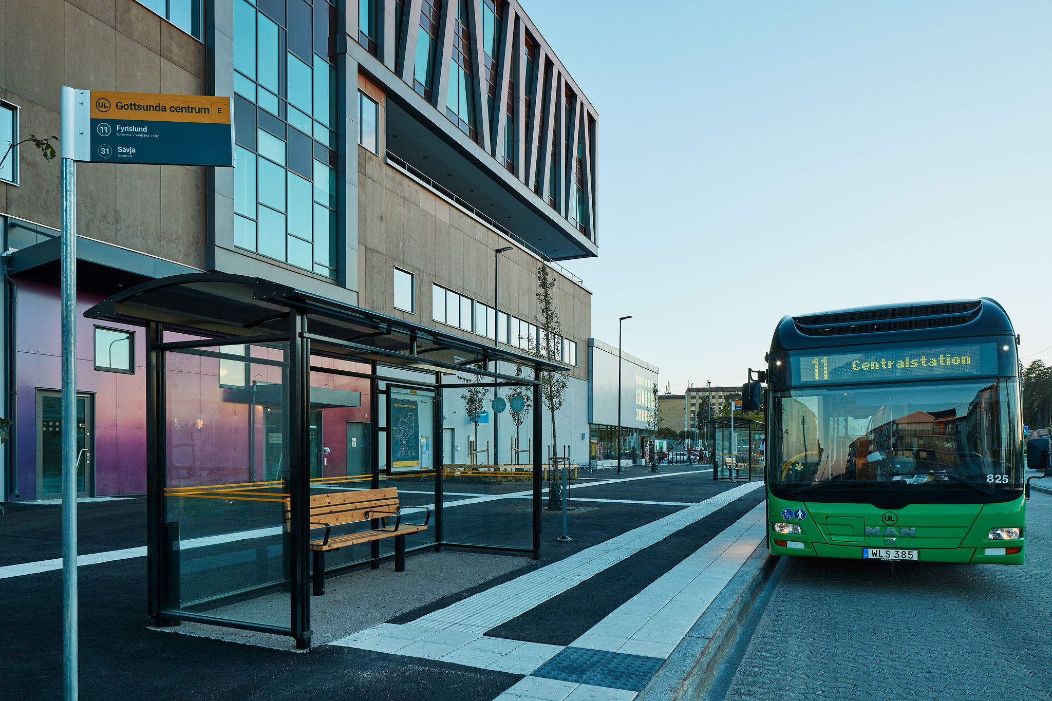 Exteriör bild på Gottsunda Centrums norra gavel. Entré 3B syns bakom busshållplatsen. Buss nummer 11